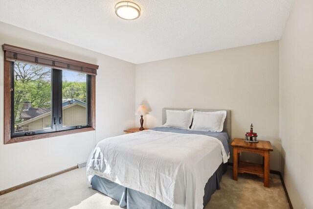 bedroom featuring baseboards and light colored carpet