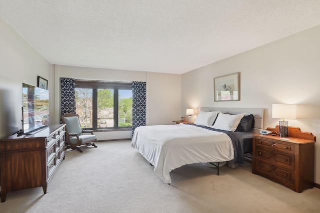 bedroom featuring light colored carpet and a textured ceiling