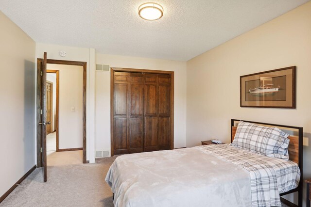 bedroom with light colored carpet, a closet, visible vents, and baseboards