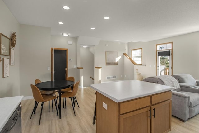 kitchen with light wood-type flooring, a center island, and stainless steel dishwasher