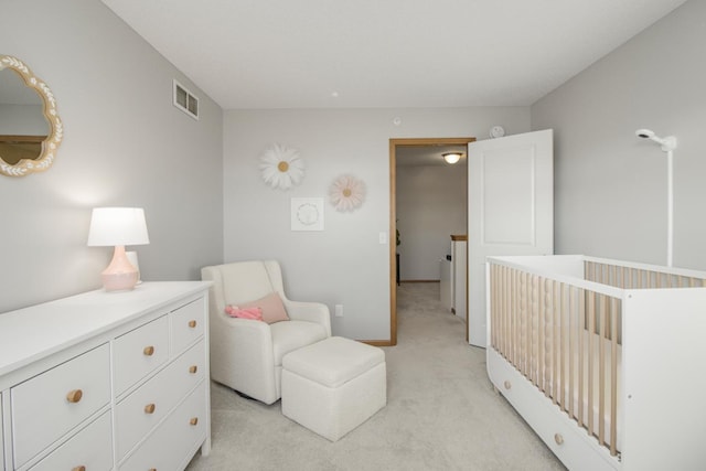 bedroom featuring light carpet and a nursery area