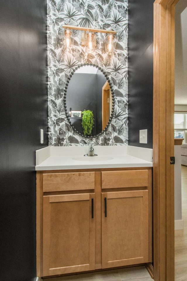 bathroom with vanity and wallpapered walls