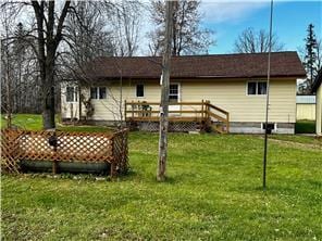 back of house featuring a deck and a lawn