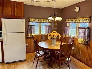 dining space with plenty of natural light, light hardwood / wood-style floors, and an inviting chandelier