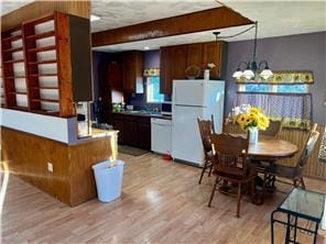 kitchen featuring hanging light fixtures, white appliances, a chandelier, and light wood-type flooring