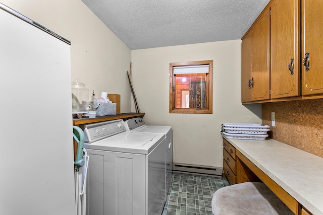 washroom with baseboard heating, cabinets, washer and dryer, and a textured ceiling