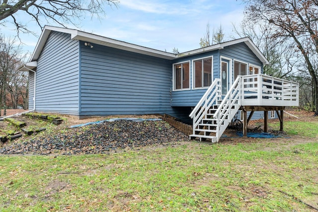 back of house with a lawn, a sunroom, and a deck