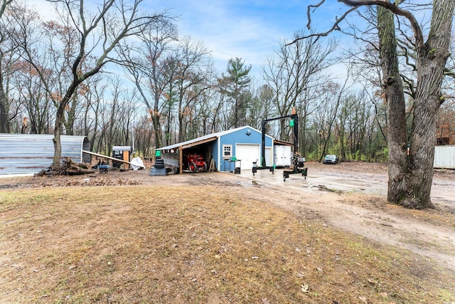 view of yard featuring a carport, a garage, and an outdoor structure