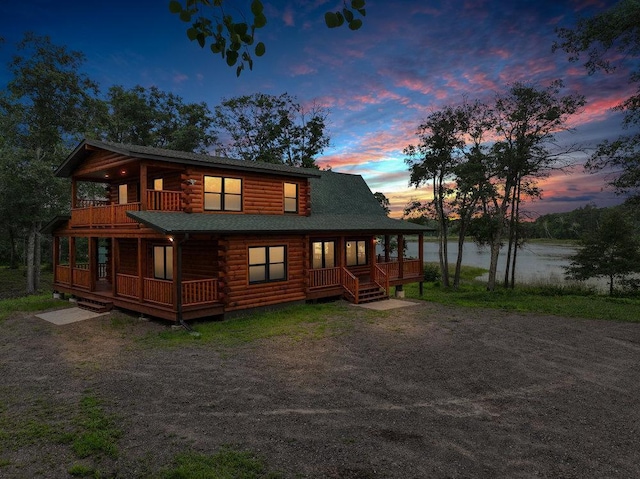 view of front of house featuring a balcony and a water view