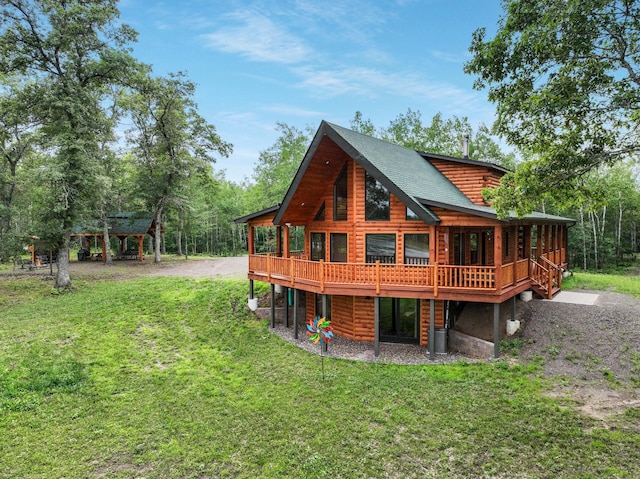 back of property with a wooden deck and a yard