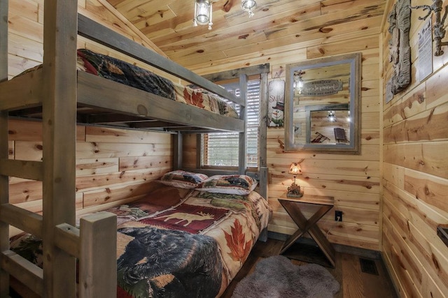 bedroom featuring hardwood / wood-style flooring, lofted ceiling, wooden walls, and wooden ceiling