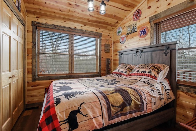 bedroom featuring a closet, wooden walls, wood ceiling, dark wood-type flooring, and lofted ceiling