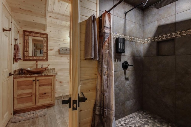 bathroom with wood-type flooring, vanity, wooden walls, a shower with shower curtain, and wood ceiling