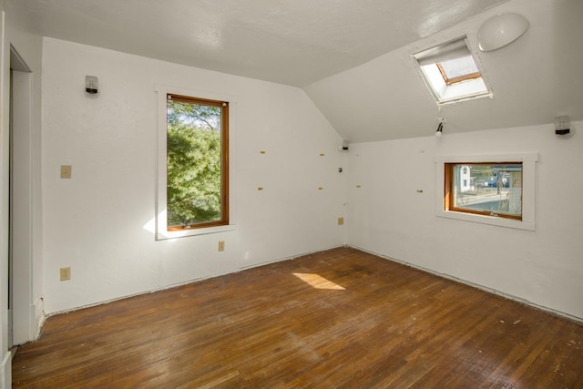 bonus room featuring lofted ceiling with skylight and hardwood / wood-style flooring