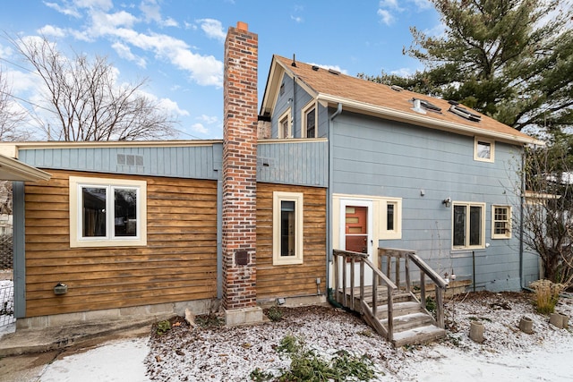 rear view of property featuring a chimney