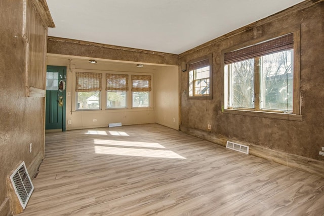 spare room with light wood-style floors and visible vents