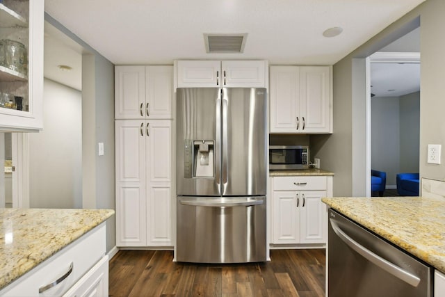 kitchen featuring light stone counters, stainless steel appliances, dark hardwood / wood-style floors, and white cabinets