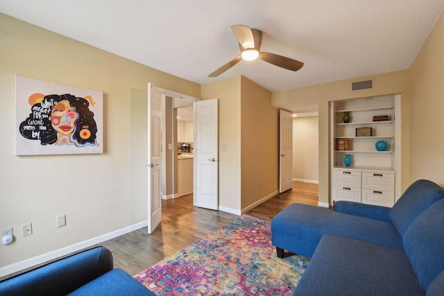 living room featuring wood-type flooring and ceiling fan