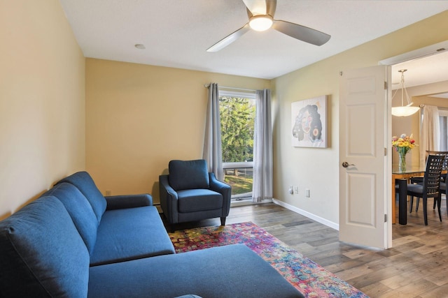 living room featuring wood-type flooring and ceiling fan