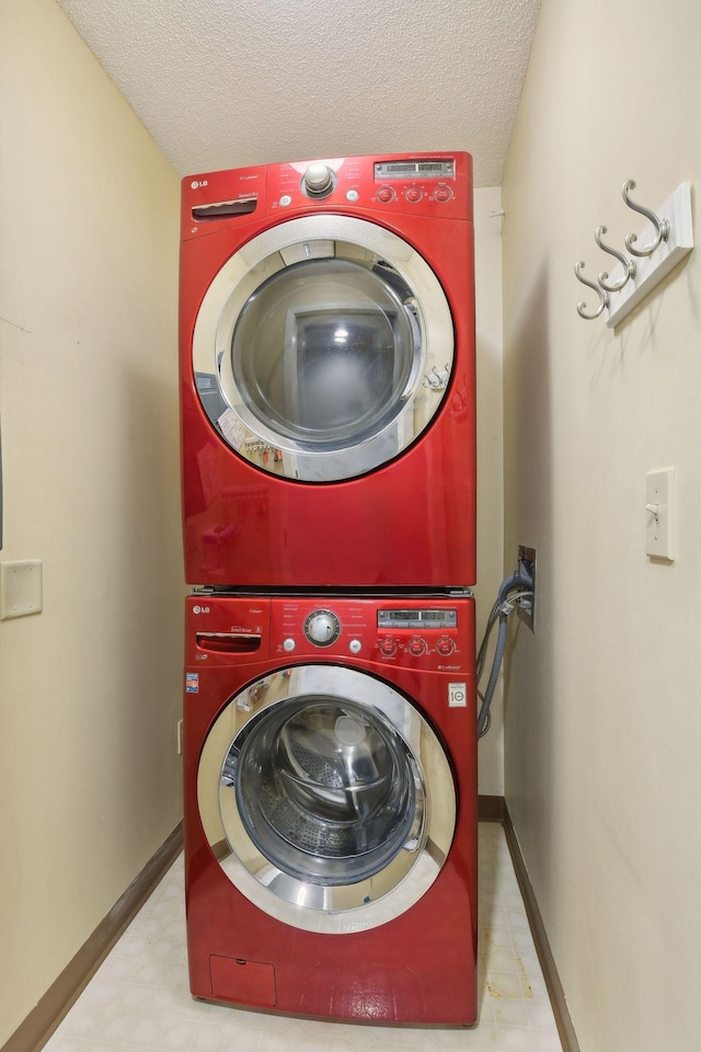 laundry area with stacked washer / drying machine and a textured ceiling