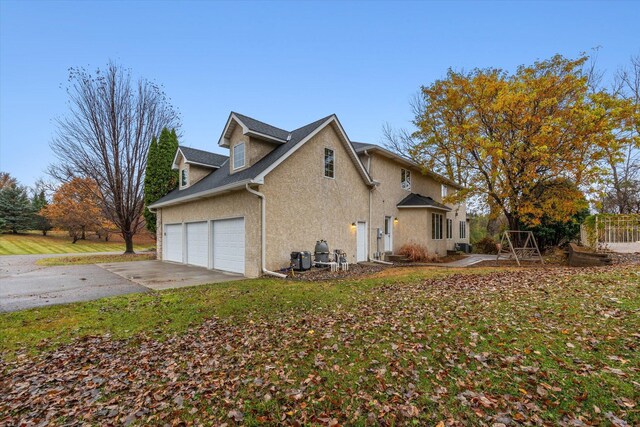 view of side of property featuring a lawn and a garage