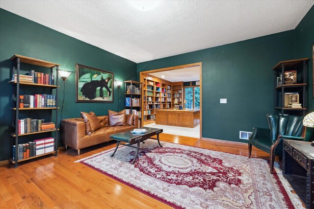 living room with wood-type flooring and a textured ceiling