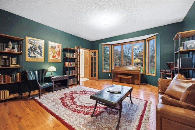 living room featuring wood-type flooring and a textured ceiling