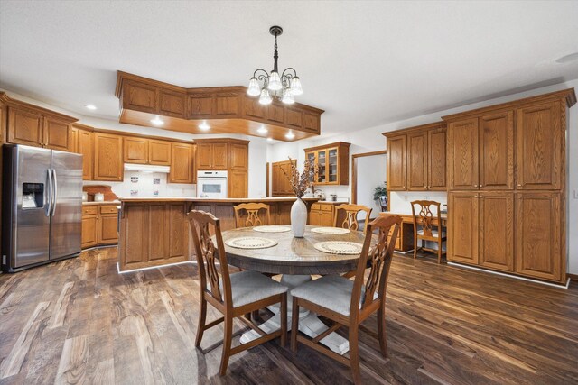 dining area with dark wood-type flooring and a chandelier