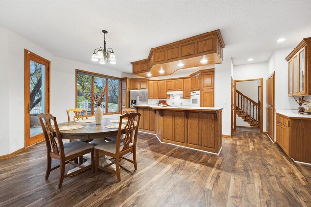 dining space with dark hardwood / wood-style floors and an inviting chandelier