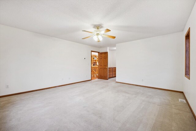 carpeted empty room featuring ceiling fan and a textured ceiling