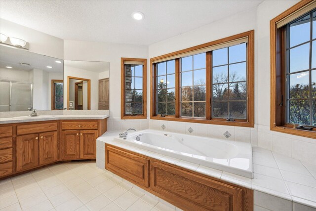 bathroom featuring vanity, a wealth of natural light, a textured ceiling, and tile patterned floors