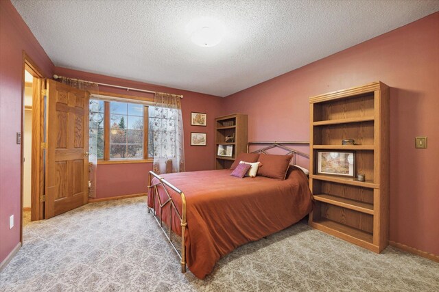 bedroom with light carpet and a textured ceiling