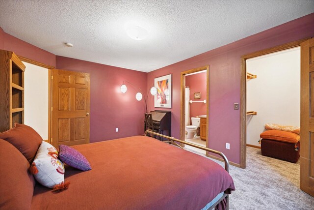 carpeted bedroom featuring connected bathroom and a textured ceiling