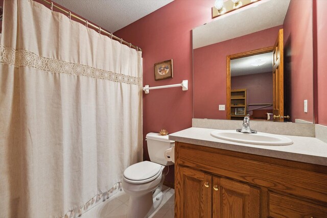 bathroom with toilet, vanity, and a textured ceiling