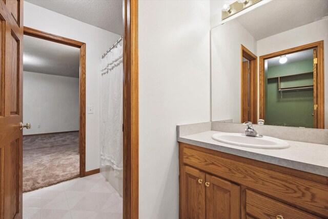 bathroom featuring vanity, curtained shower, and a textured ceiling