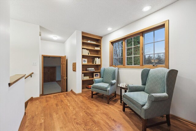 sitting room with a textured ceiling and hardwood / wood-style flooring