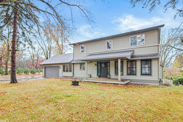 view of front of property with a front lawn, a garage, and covered porch