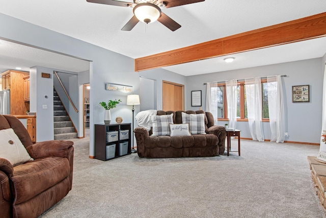 carpeted living room with ceiling fan and beam ceiling