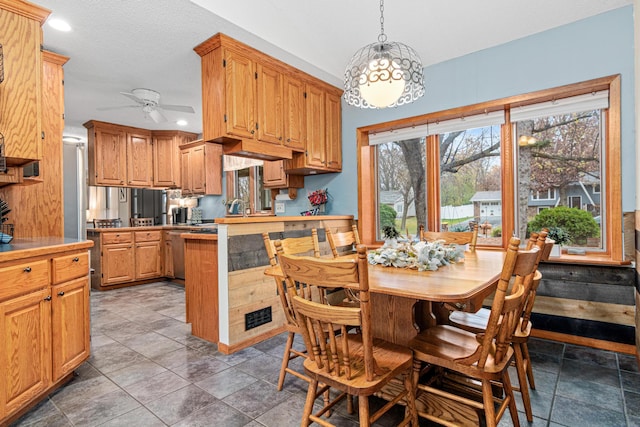 kitchen with pendant lighting, a textured ceiling, ceiling fan, and kitchen peninsula