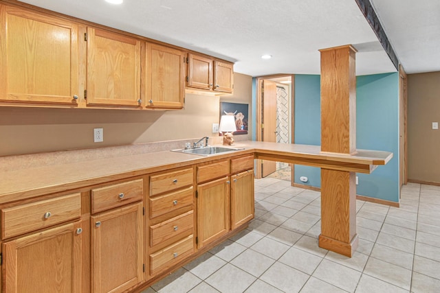 kitchen featuring light countertops, light tile patterned floors, and a sink