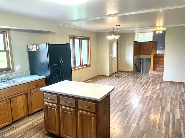12303 71st Ave SW, Motley, MN 56466 - kitchen with black fridge, light wood-style floors, light countertops, a sink, and ornamental molding