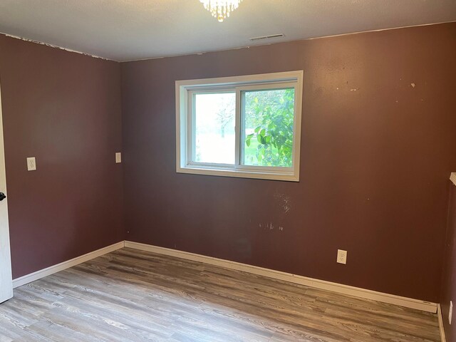 12303 71st Ave SW, Motley, MN 56466 - spare room featuring wood finished floors, baseboards, and a chandelier