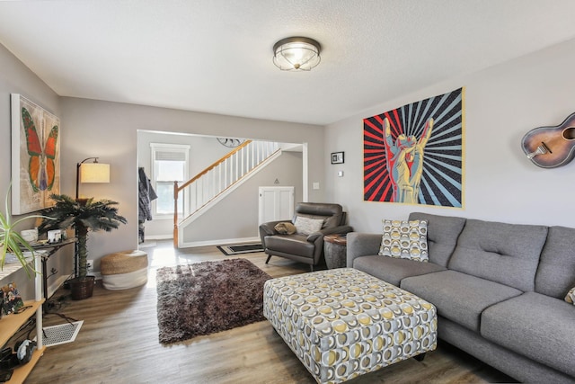 living room with wood-type flooring and a textured ceiling