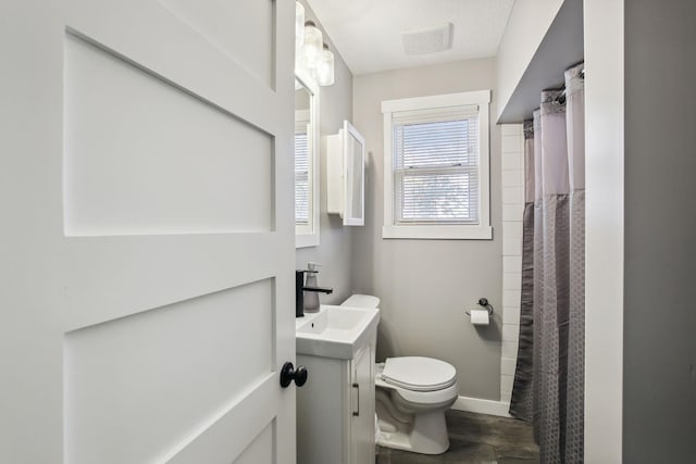 bathroom with toilet, vanity, wood-type flooring, and walk in shower