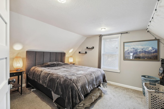 bedroom with a textured ceiling, light carpet, and lofted ceiling