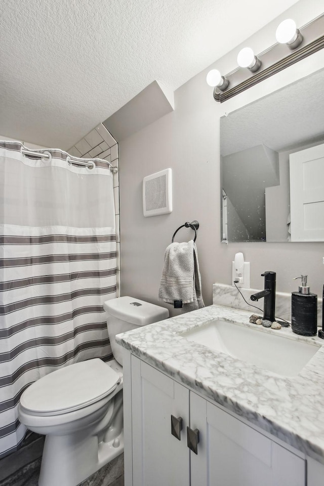 bathroom featuring toilet, vanity, and a textured ceiling