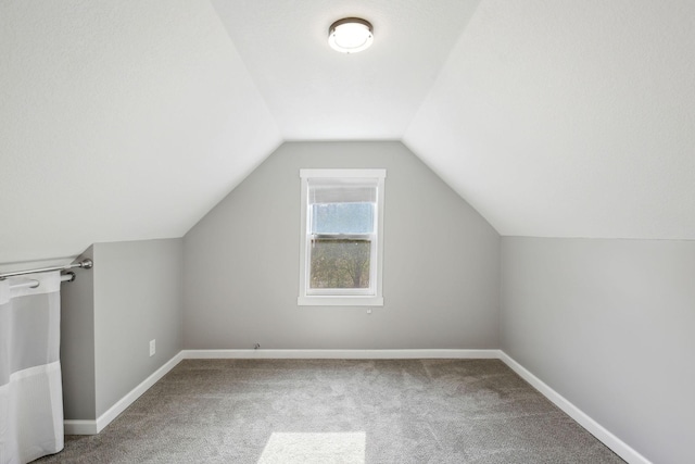 bonus room featuring lofted ceiling and carpet