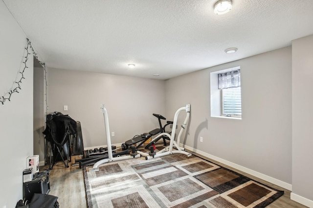 workout room featuring wood-type flooring and a textured ceiling