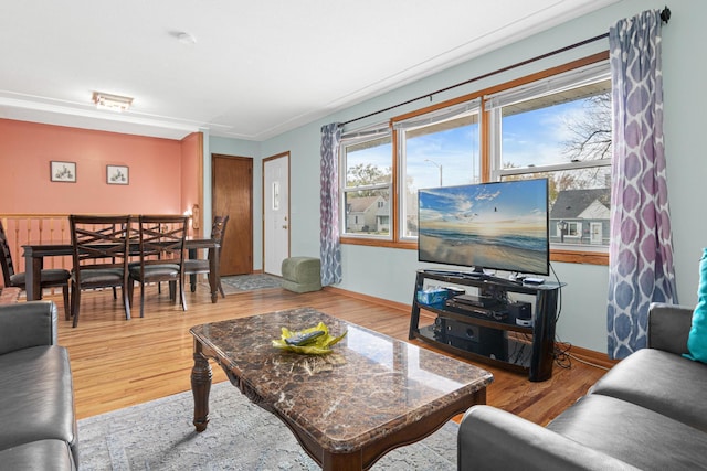 living room with ornamental molding and light wood-type flooring