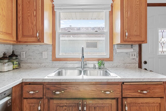 4425 2nd St NE, Columbia Heights, MN 55421 - kitchen featuring a sink, brown cabinetry, healthy amount of natural light, and decorative backsplash